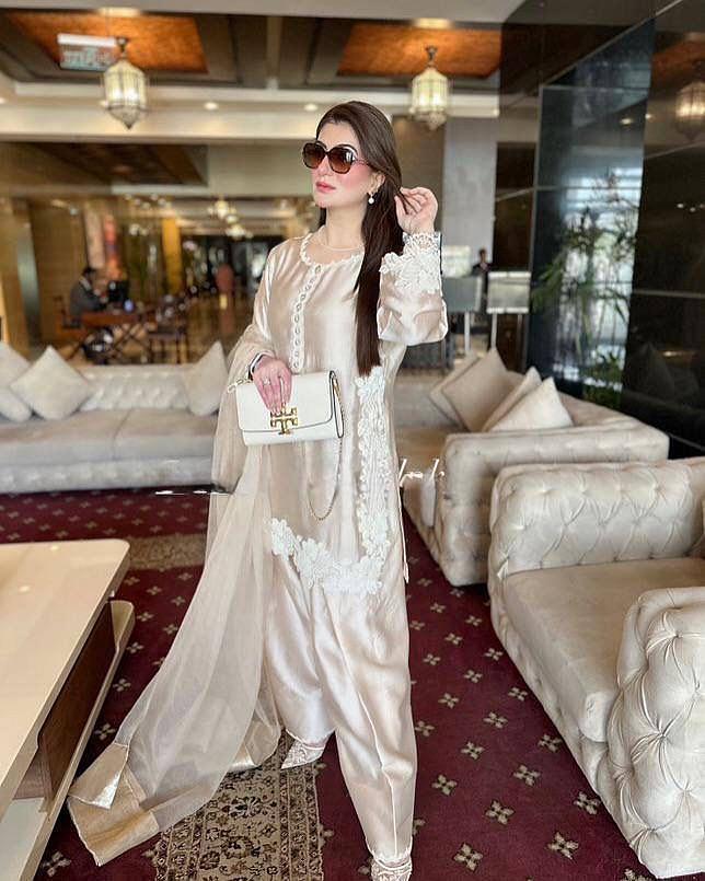 Model wearing Champagne Beige natural silk palazzo suit set with pearl hand work and soft net dupatta front view
