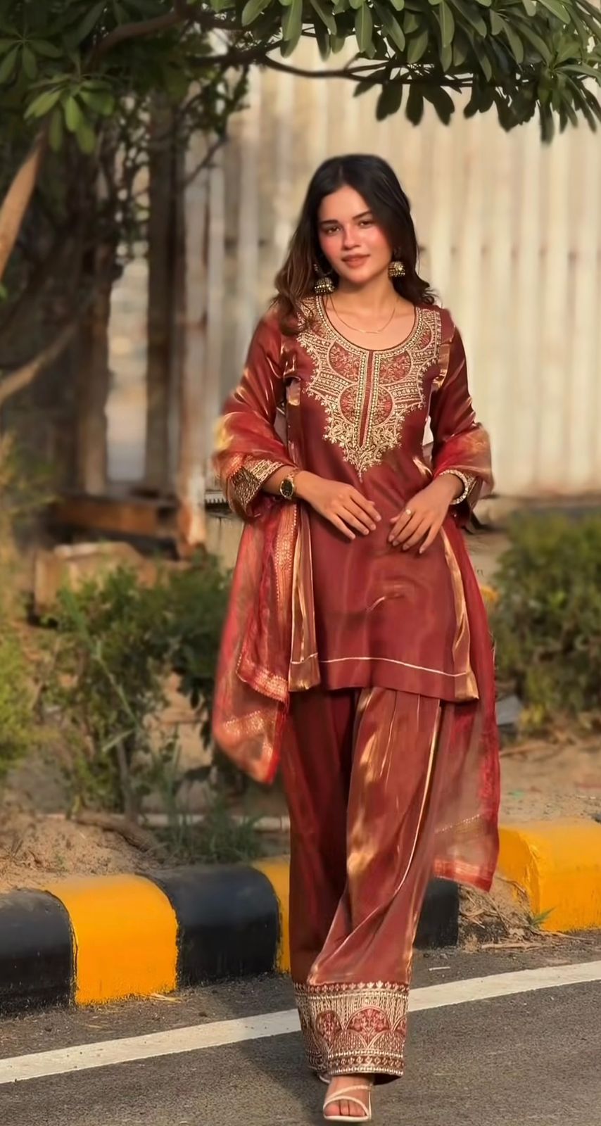 Outdoor front view of rust brown embroidered farshi salwar suit