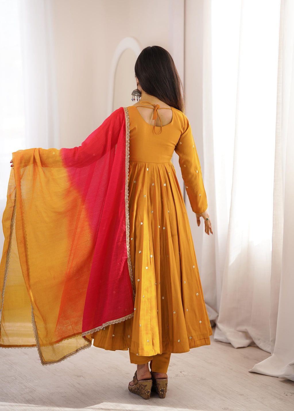 Back view of Mustard Gold Roman Silk embroidered mirror work Anarkali suit with printed dupatta