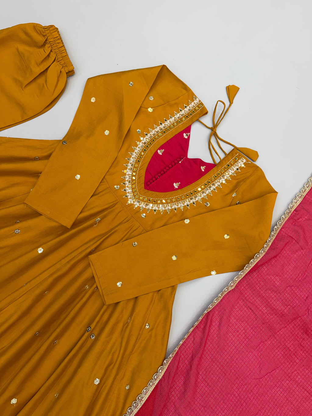 Flat lay of Mustard Gold Roman Silk embroidered sequence and real mirror work Anarkali suit set with matching bottom and printed dupatta