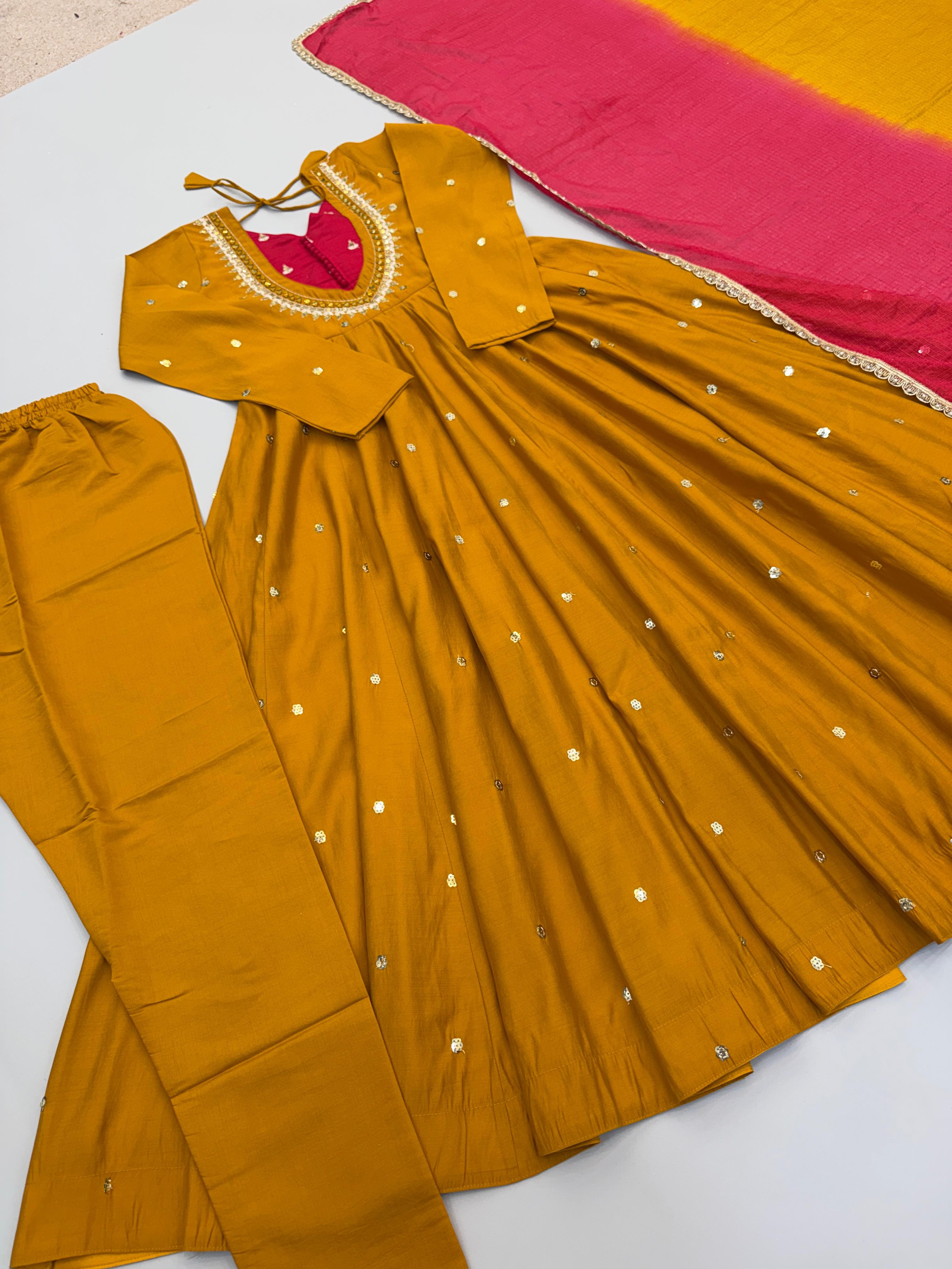 Flat lay of Mustard Gold Roman Silk embroidered sequence and real mirror work Anarkali suit set with matching bottom and printed dupatta