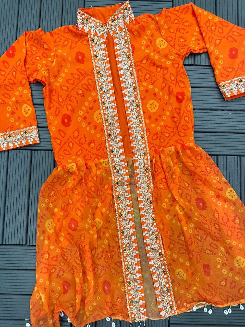 Orange shrug lehenga set flat lay with embroidered shrug and lehenga