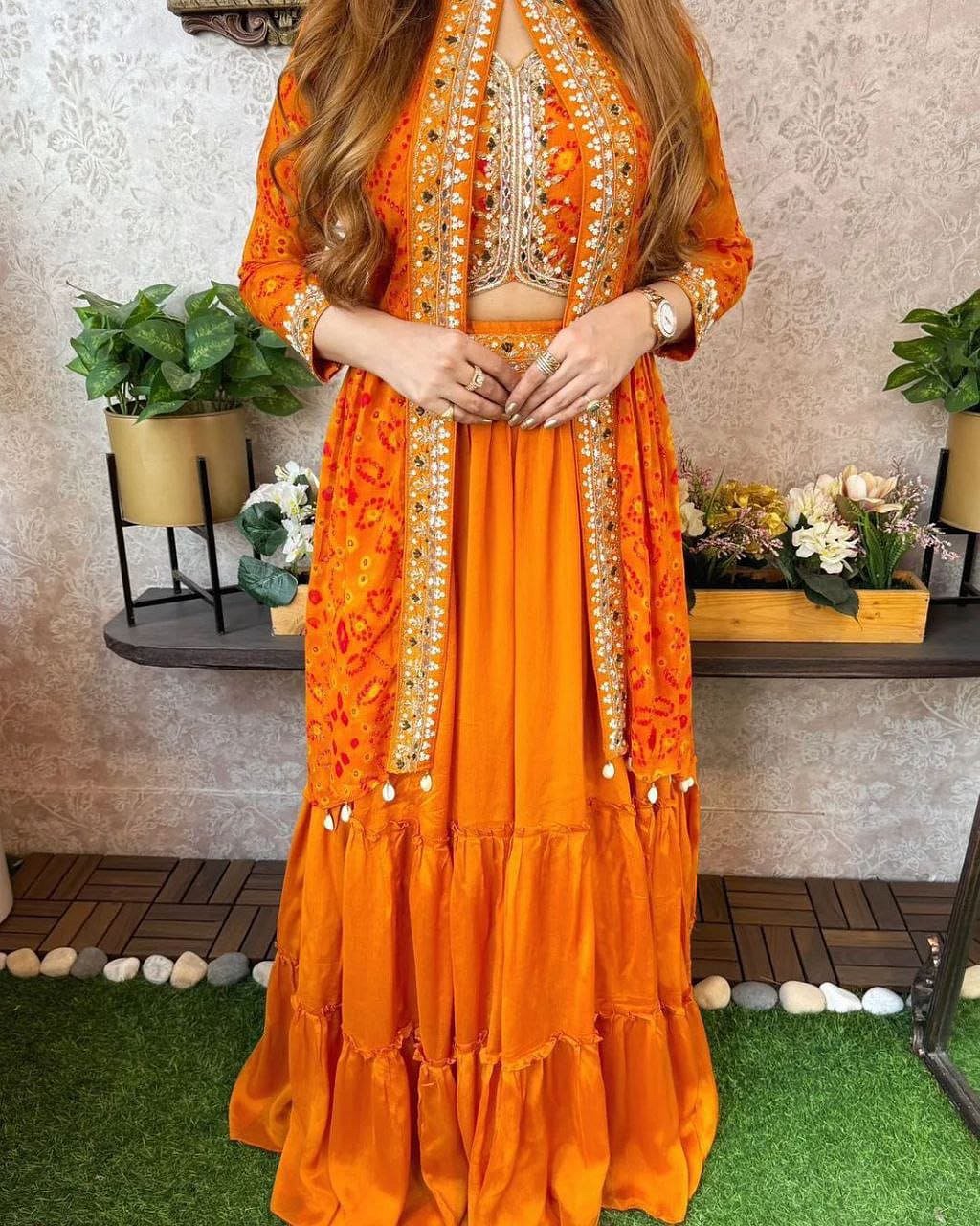 Model wearing Orange shrug lehenga set with embroidered shrug and flared lehenga