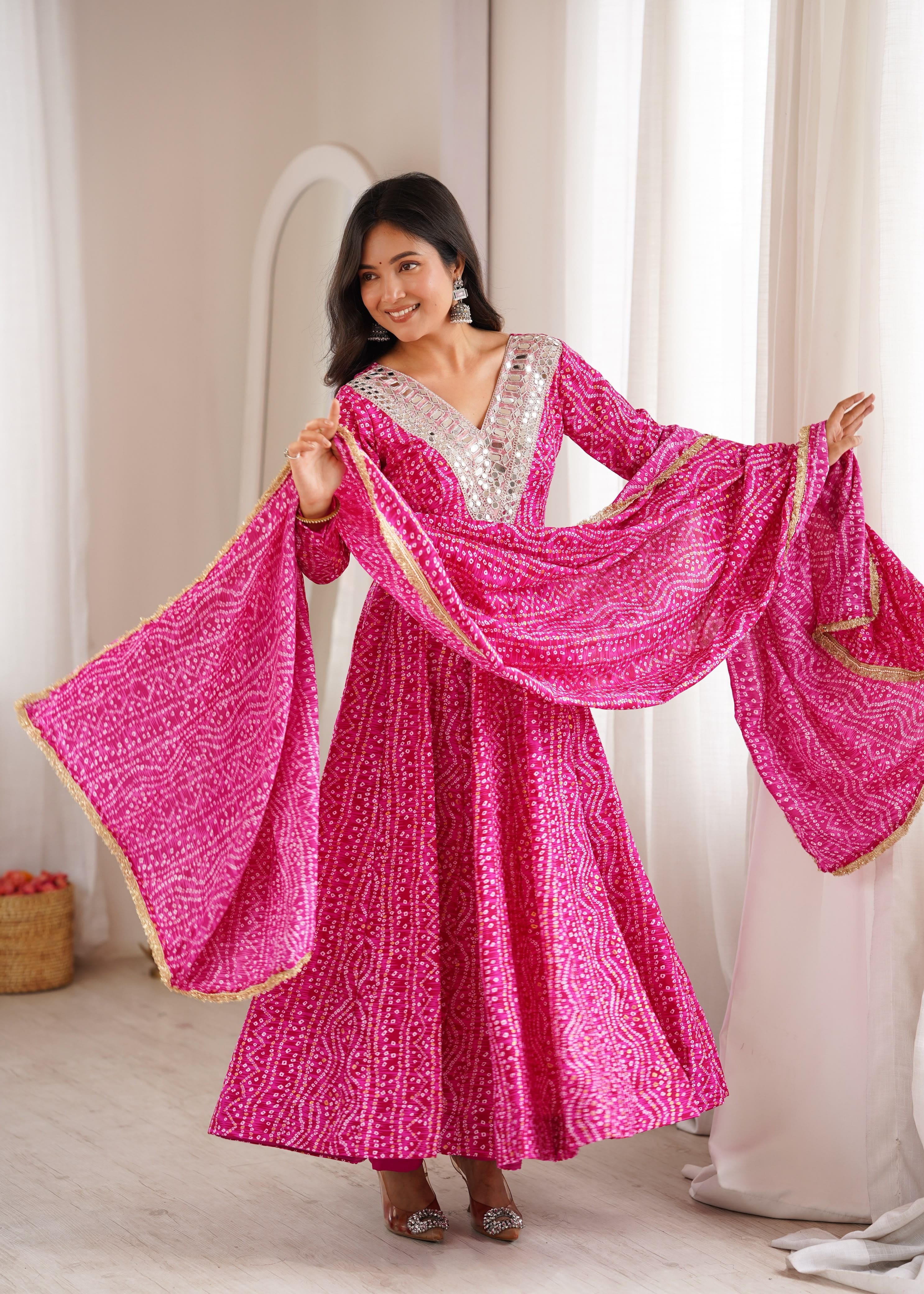 Woman posing in Rani Pink mirror embroidery gown set