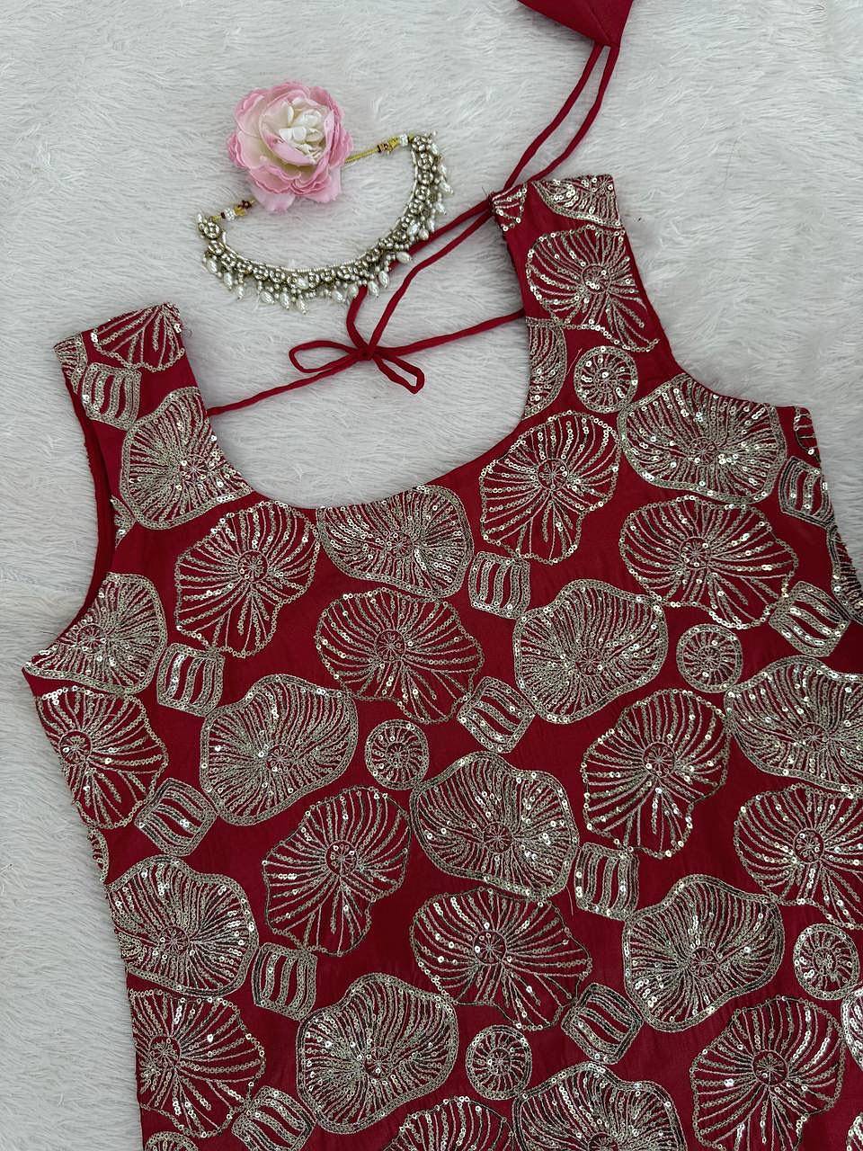 Close-up of thread and sequence embroidery on red kurti