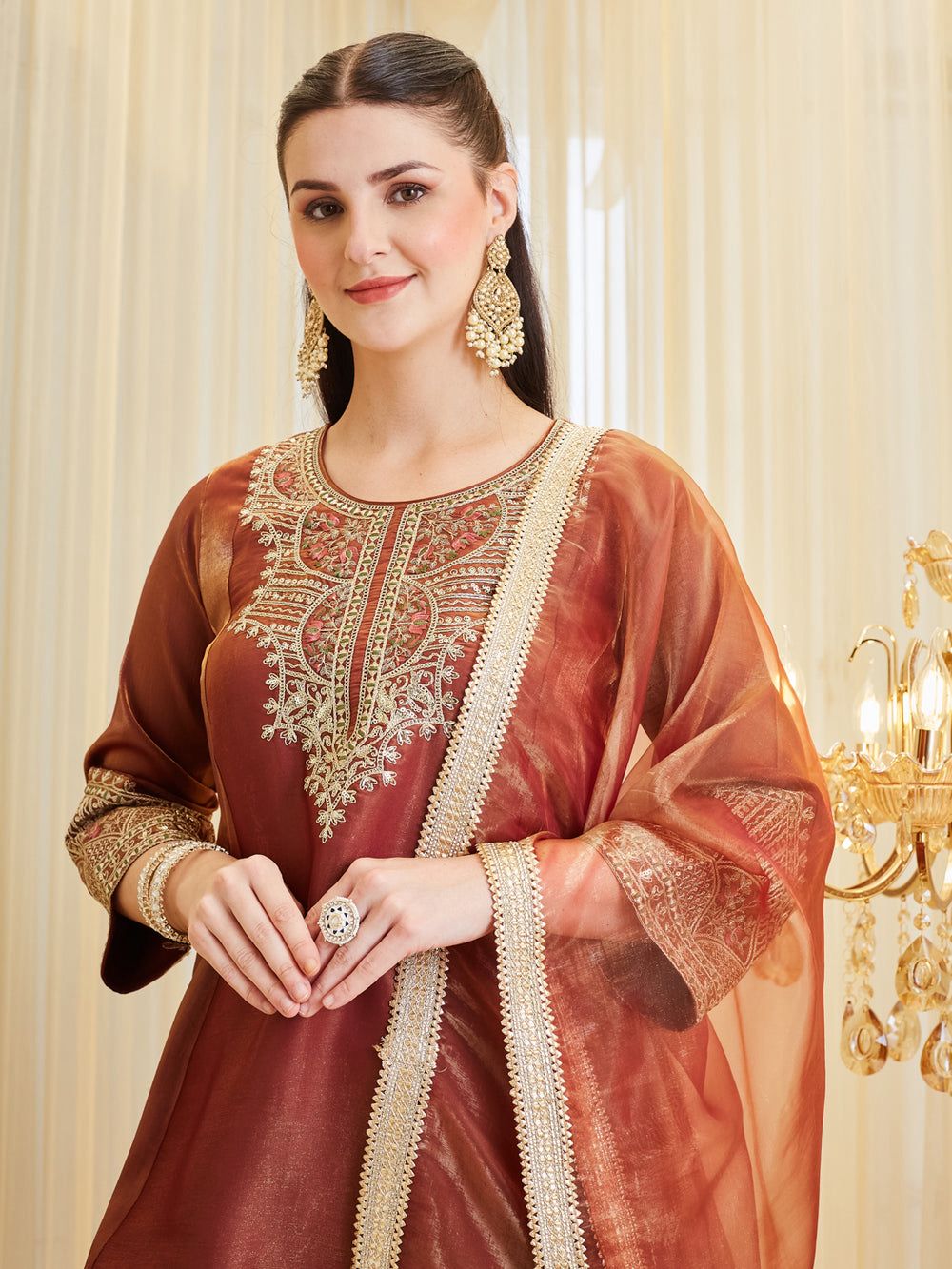 Close-up of embroidery sequence work on rust brown kurti neckline