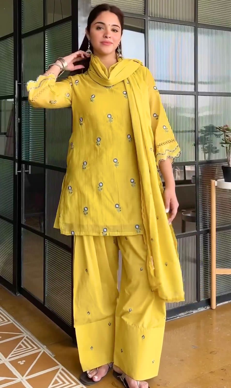Woman wearing Sunshine Yellow Mul Chandheri embroidered Farshi Palazzo suit with matching dupatta front view