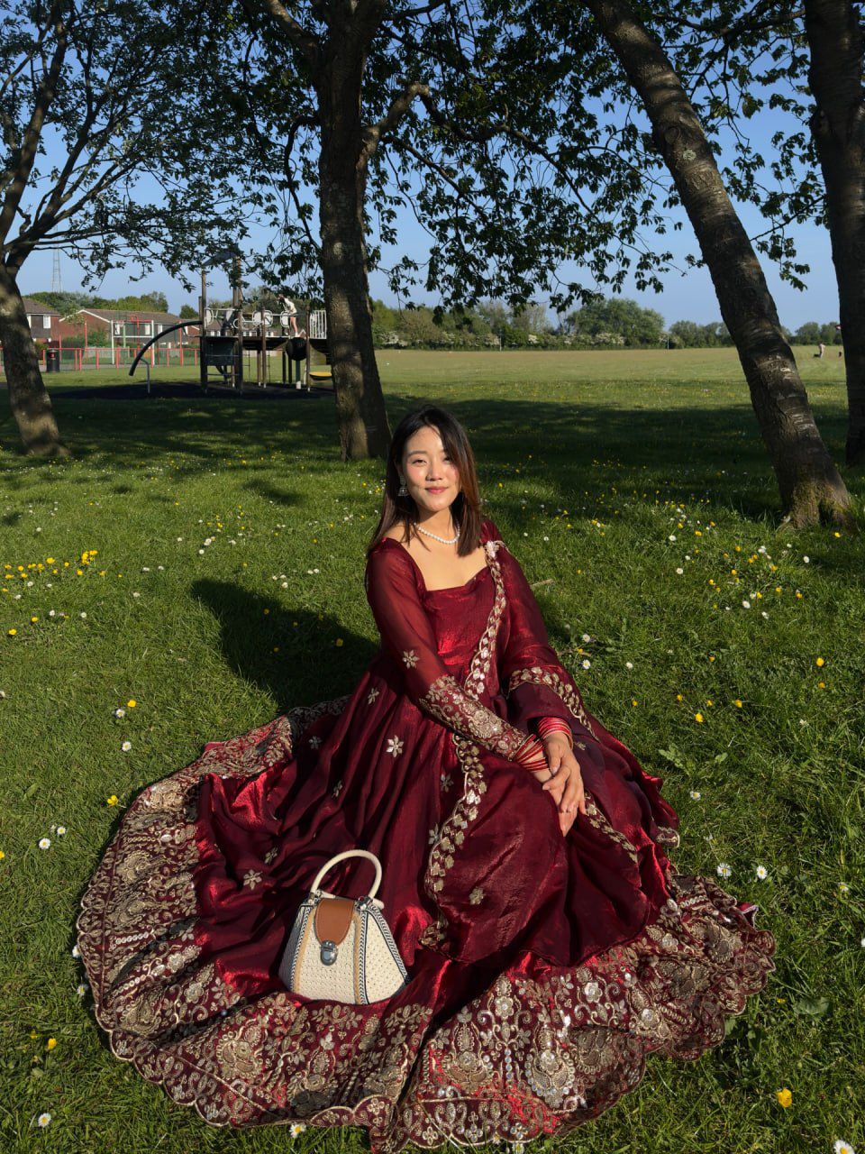 Model posing outdoors in Wine Burgundy Fendy silk Anarkali suit with embroidered dupatta